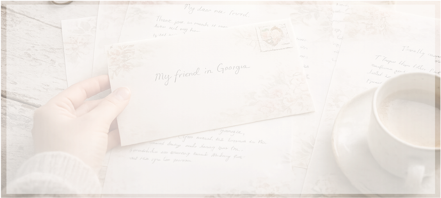 A handwritten letter on custom stationery being read beside a cup of coffee.